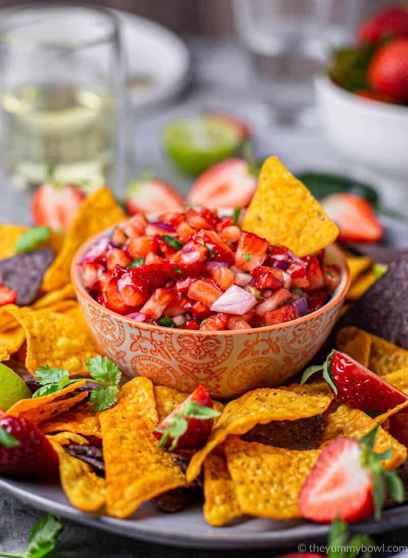 strawberry salsa in a bowl with nachos tortilla chips around