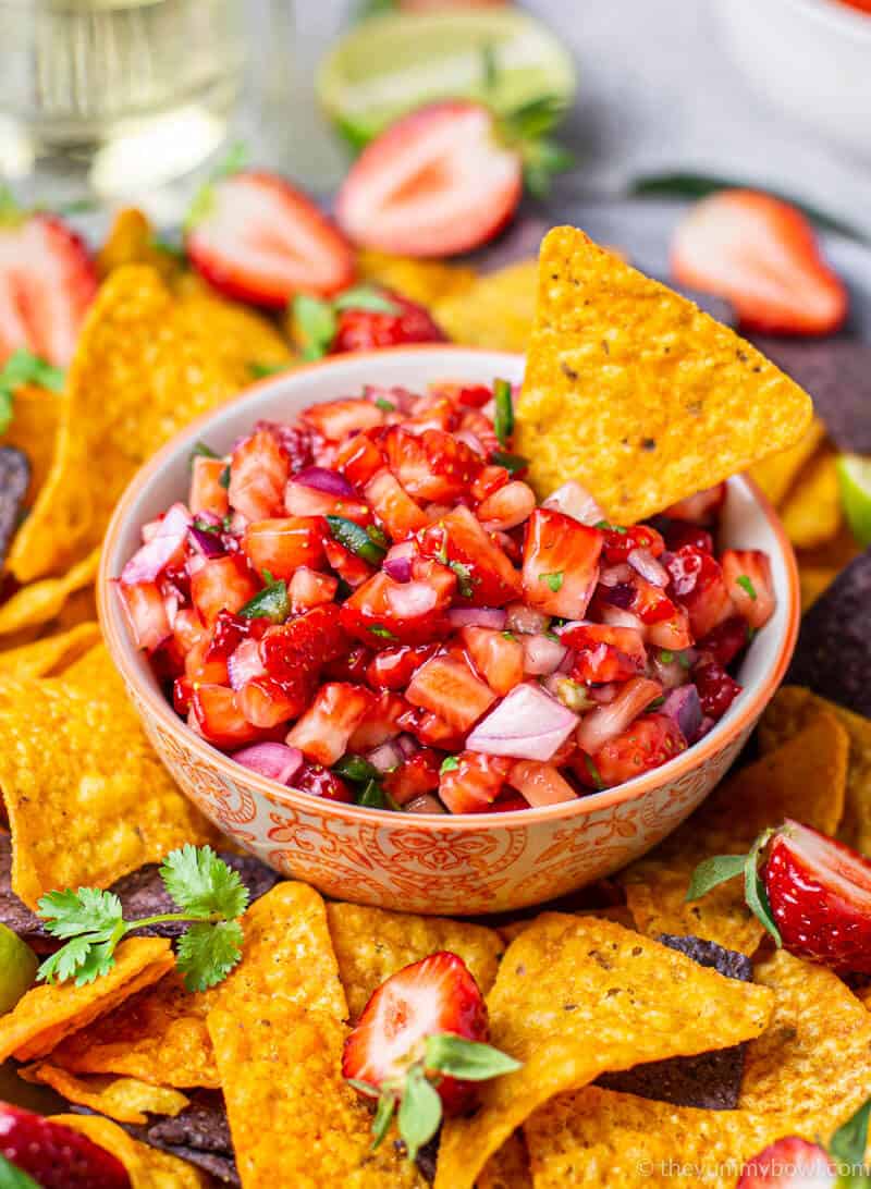 strawberry salsa in a bowl with nachos tortilla chips around