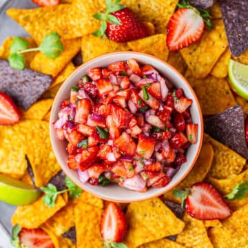 strawberry salsa in a bowl with nachos tortilla chips around