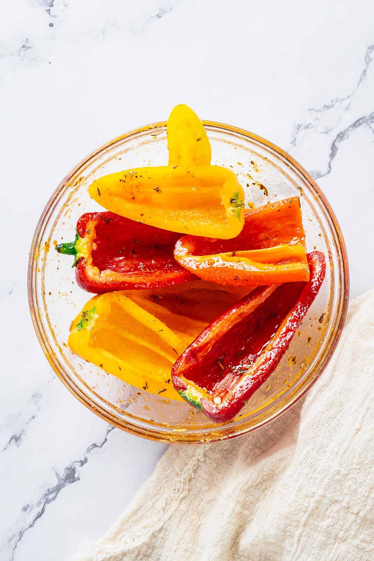 baby bell peppers in a bowl drizzled with marinade