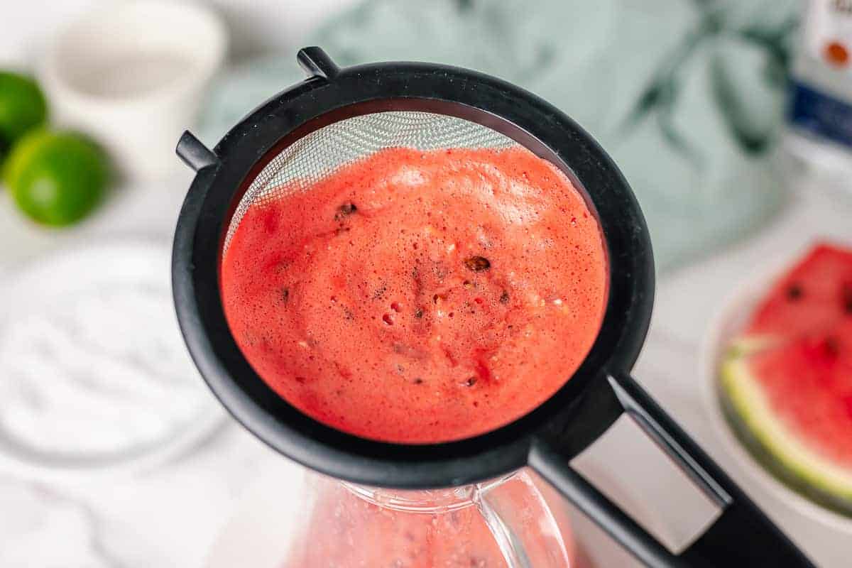 strain the watermelon seeds and excess flesh in a pitcher